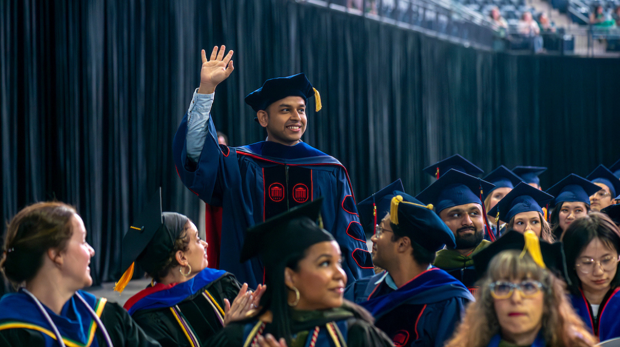 Student waving at graduation