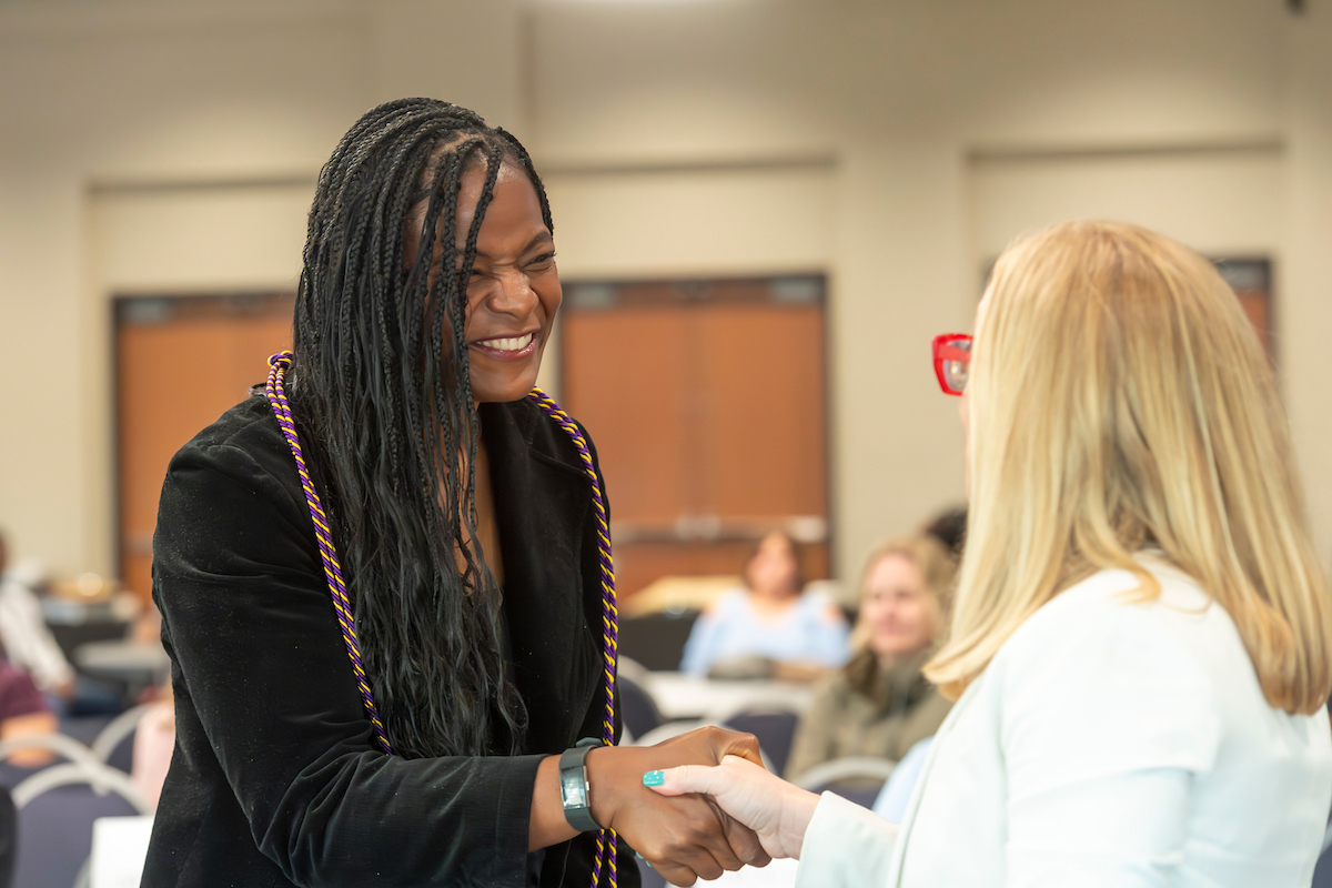 Graduate student shaking Dean Kluck's hand