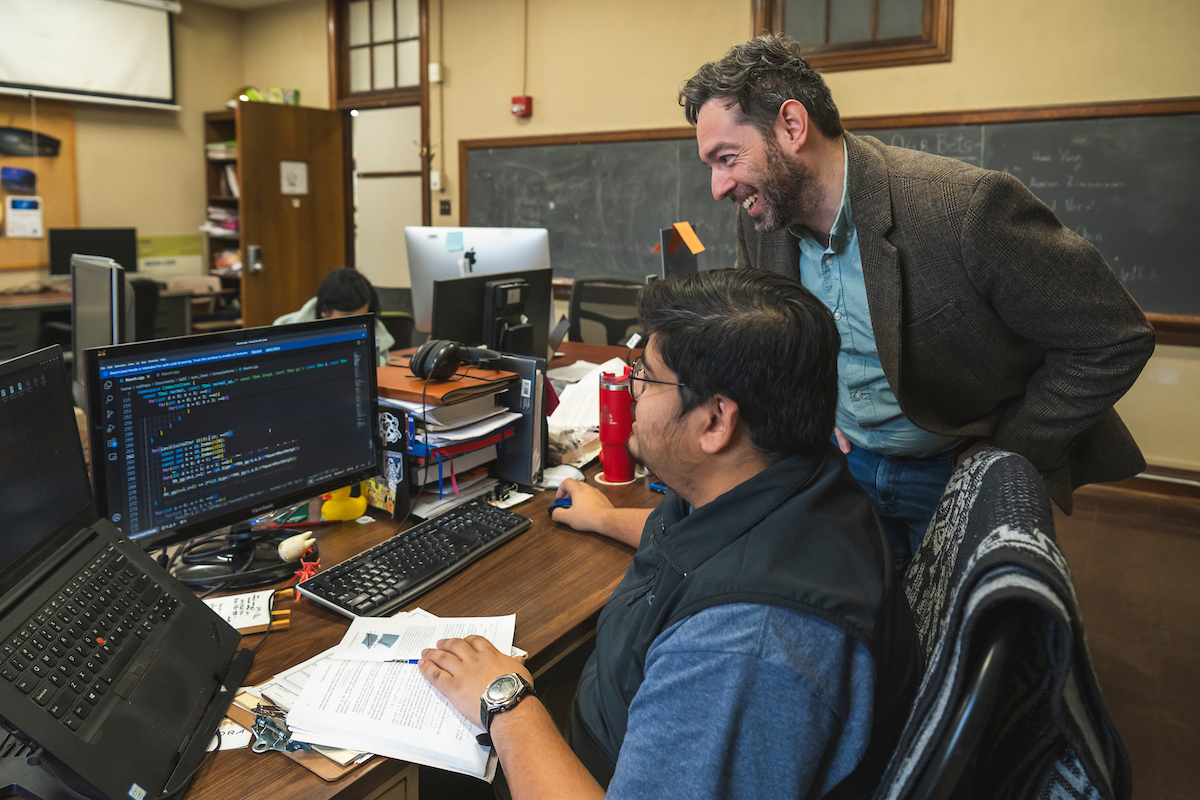 Student and professor working together on a computer.